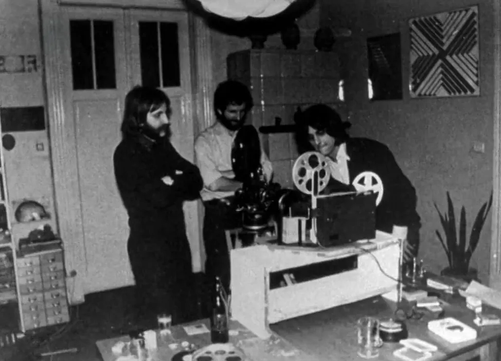 Archív felvétel: filmvetítés egy falusi szobában, filmvetítő géppel az asztalon.